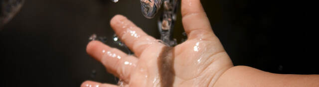 Baby holding hand under running water