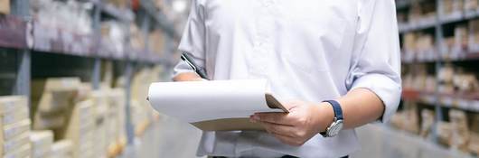 Man checking items on a clipboard in a warehouse