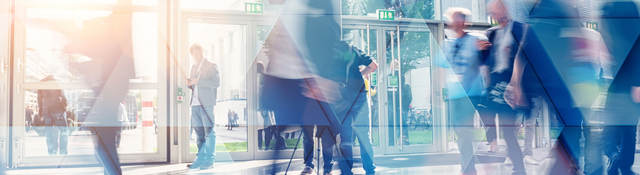 Business people walking in the lobby of a building with glass windows