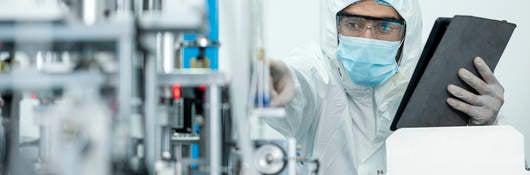 Shot of Caucasian Engineers using digital tablet for inspection quality of producing protective face mask in automated production line.