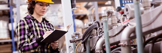 female engineer inspects industrial equipment