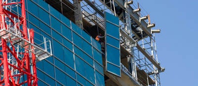 Lifting glass into place while constructing a commercial building