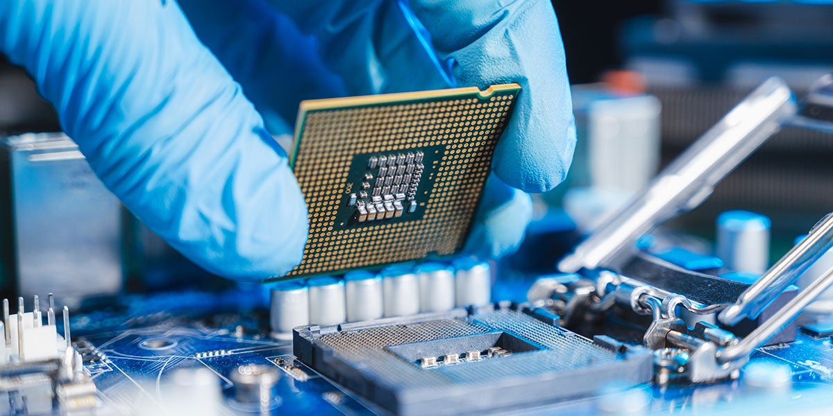 Closeup of a person wearing blue latex gloves while installing a CPU