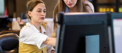 Two business colleagues collaborating in front of a computer