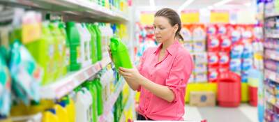 Person reading a label on a product while shopping in a store