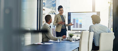 Three business colleagues reviewing metrics in a meeting