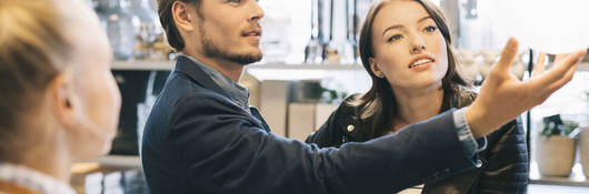 Customers shopping for lamps at a retail store.