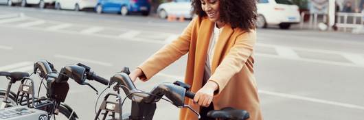 Woman in urban station with electric bicycles