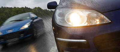 Two cars driving in the rain