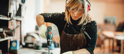 Female carpenter using power tool