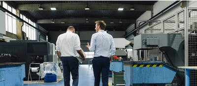 Two men walking and talking in a factory