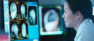 Woman in front of screen with medical scans  