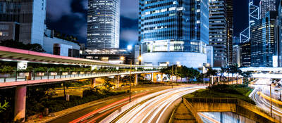 Lit city with bridges, train tracks, roads