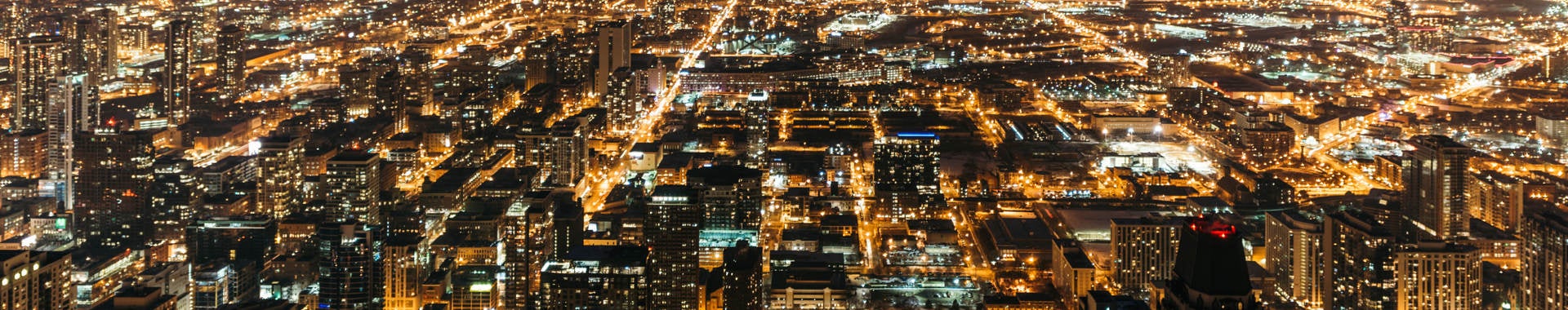 Cityscape at night with many lights from homes, businesses, roads