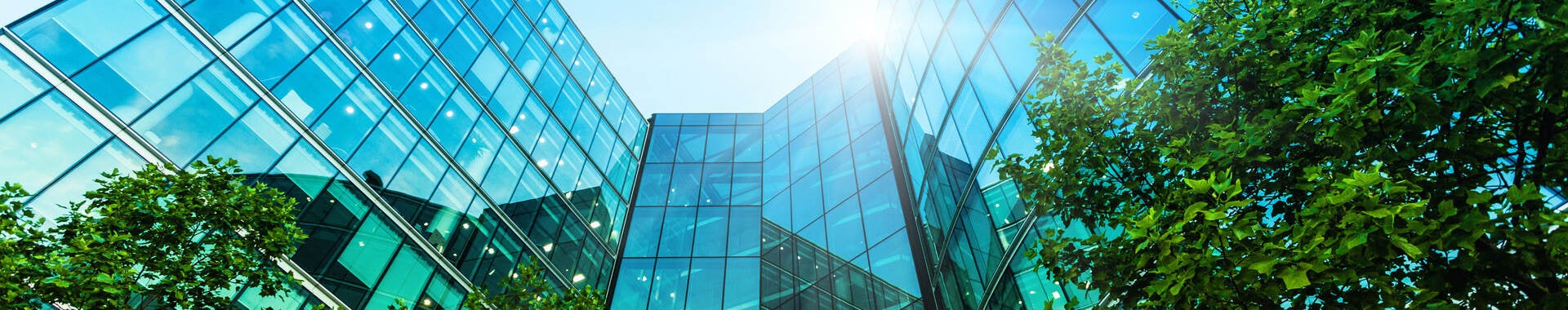 Low angle view of multi-story glass front modern office building