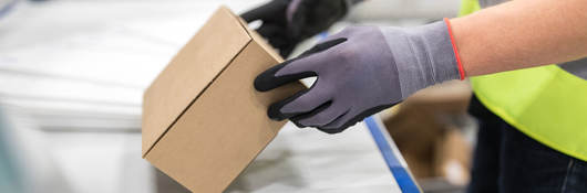 Worker checking package from conveyor belt in warehouse