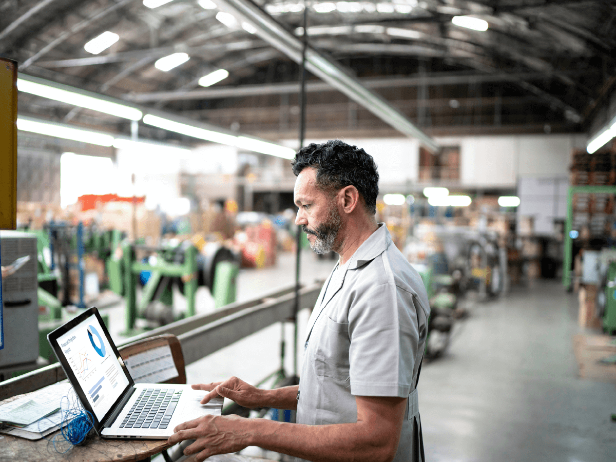 man on laptop in factory